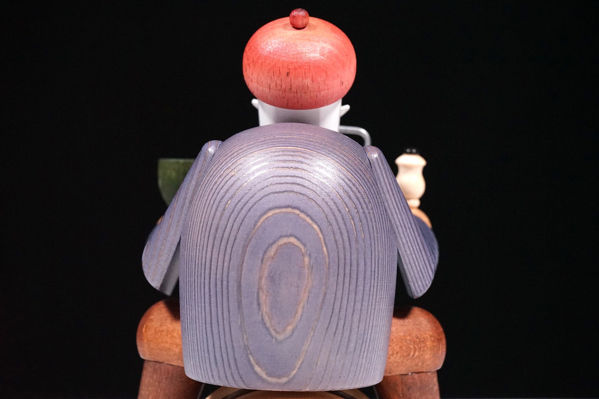 Im Bild sieht man den Räuchermann Weinhändler auf Fass von KWO (Artikelnummer: 21014). Es handelt sich um ein Detailbild der Figur - man sieht groß den Rücken der Figur mit der Holzmaserung.